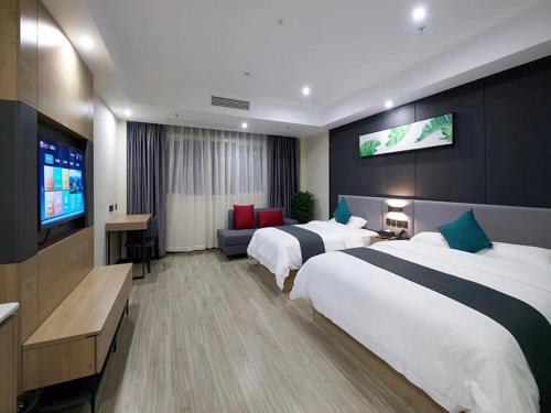 a hotel room with two beds and a flat screen tv at Up And In Hubei Xianning Tongshan County Building Material Market in Xianning