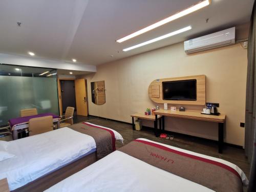 a hotel room with two beds and a flat screen tv at Thank Inn Chain Hotel Anhui Fuyang Funan County Yunhe East Road Store in Fuyang