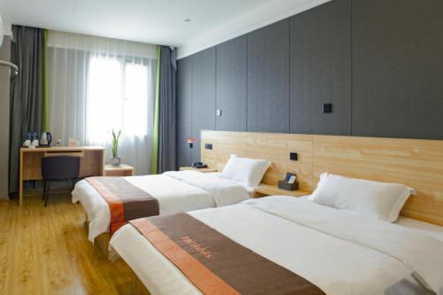 Habitación de hotel con 2 camas y escritorio en JUN Hotels Langfang Guangyang District Wanda Plaza, en Langfang