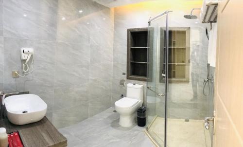 uma casa de banho com um WC e uma cabina de duche em vidro. em Thank Inn Chain Hotel Hainan Oriental City Triangle Park em Dongfang