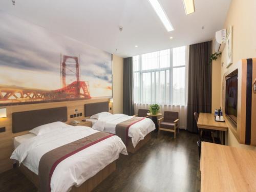 ChangshuにあるThank Inn Chain Hotel Jiangsu Suzhou Changshu Haiyu Townのベッド2台、薄型テレビが備わるホテルルームです。