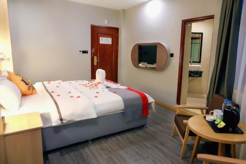 Habitación de hotel con cama y TV en JUN Hotels Sichuan Suining Chuanshan District Heping Road, en Suining