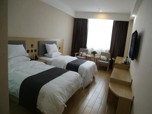a hotel room with two beds and a television at Up and In Heze Development zone Huanghe Road in Heze