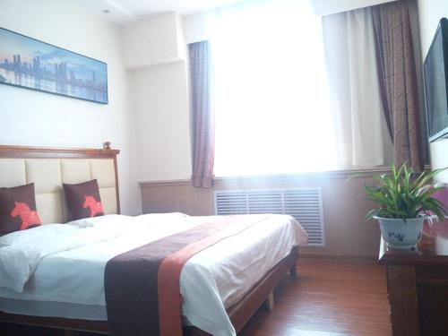 a bedroom with a large bed and a large window at JUN Hotels Yulin Yuyang District South Gate Bus Station in Yulin