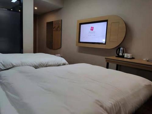 a hotel room with two beds and a flat screen tv at Thank Inn Chain Hotel Luoyang Mengjin County Yellow River Avenue Bus Station in Luoyang