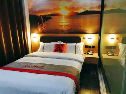 een slaapkamer met een bed met een schilderij aan de muur bij JUN Hotels Shandong Taian Dongping Museum in Dongping