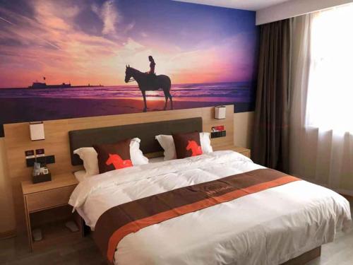 a bedroom with a bed with a painting of a person riding a horse at JUN Hotels Shandong Liaocheng Dong'a County Bus Station Store in Liaocheng