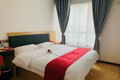 Thank Inn Chain Hotel Guiyang Nanming District Huaguoyuan Yan'an South Road في غوييانغ: غرفة نوم بسرير كبير عليها ورد