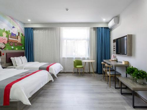 a hotel room with two beds and a desk at JUN Hotels Shanxi Taiyuan Yingze District Chaoyang Street Store in Taiyuan