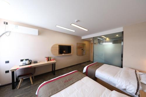 a hotel room with two beds and a desk and a tv at Thank Inn Plus Hotel Qingdao Jiaozhou Jiaoping Road high-speed intersection in Qingdao