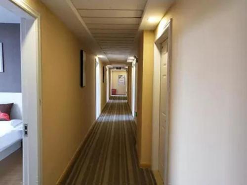 einen Flur mit gelben Wänden und einem langen Korridor in der Unterkunft JUN Hotels Jiangsu Suzhou Kunshan Lujia Town Tongjin Road in Kunshan