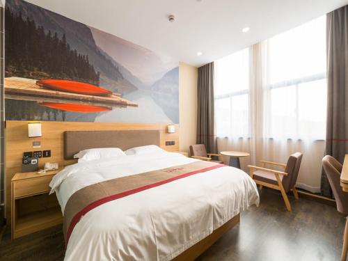 um quarto de hotel com uma cama grande e um quadro em Thank Inn Chain Hotel Shanghai Songjiang District Yongfeng Road Store em Xangai