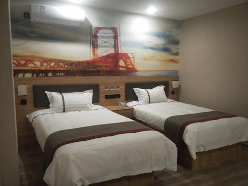 two beds in a hotel room with a painting on the wall at Thank Inn Chain Hotel Jiangsu Xuzhou Suining County Renmin West Road Store in Xuzhou