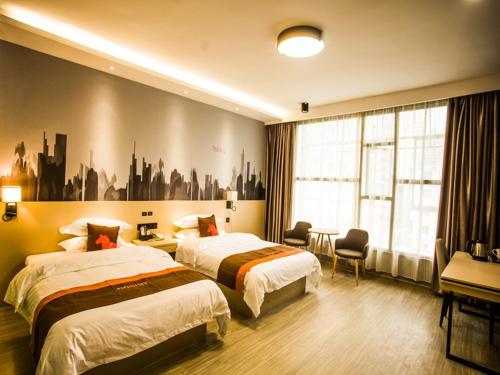 um quarto de hotel com duas camas e uma janela em JUN Hotels Liuzhou Sanjiang County Dongxiang Avenue em Sanjiang