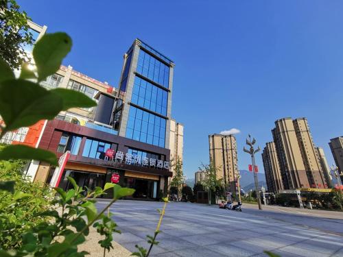 uma rua da cidade com edifícios altos em uma cidade em Thank Inn Chain Hotel Guangan Huaying Phoenix City em Shuang-ho