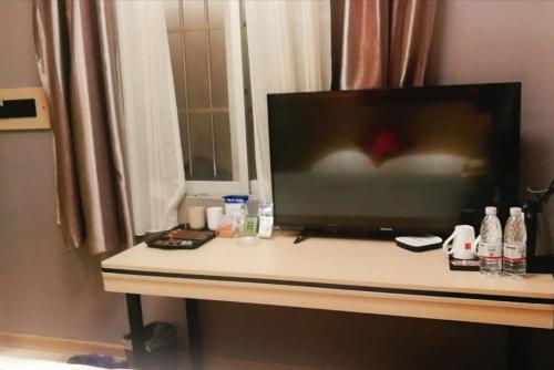 uma televisão de ecrã plano em cima de uma mesa em JUN Hotels Liuzhou Sanjiang County Dongxiang Avenue em Sanjiang