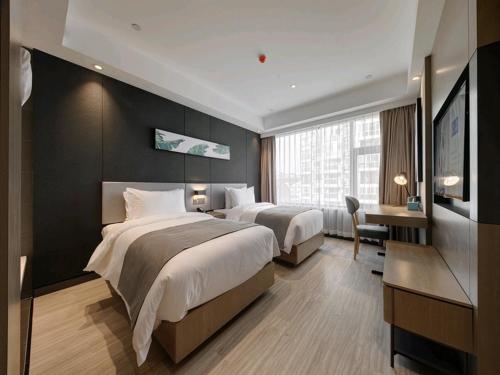 Habitación de hotel con 2 camas y escritorio en Up And In Henan Anyang Hongqi Road Wal-Mart en Anyang