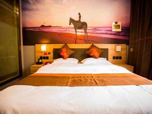 Dormitorio con cama y pintura de una persona montada a caballo en JUN Hotels Shandong Heze Mudan District Sanjiao Garen, en Heze