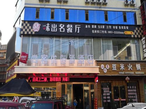 un bâtiment avec un panneau sur son côté dans l'établissement Thank Inn Chain Hotel Guizhou Zunyi Renhuai People's Hospital Store, à Zunyi