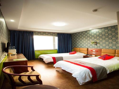JUN Hotels He'nan Anyang Huaqiang Xintiandi tesisinde bir odada yatak veya yataklar