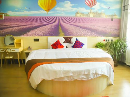 a bedroom with a large bed and a painting of balloons at JUN Hotels Shandong Ji'nan Zhangqiu Diao Town Chemical Industrial Park 