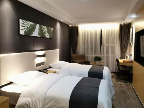 a hotel room with two beds and a desk at Thank Inn Chain Hotel Shandong Linyi Junan County Longshan Road in Linyi