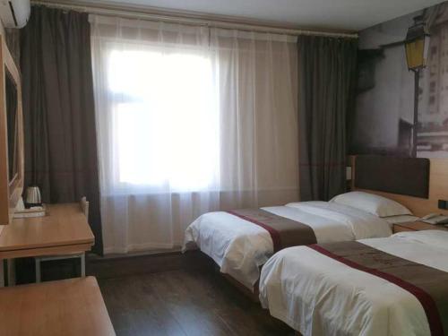 a hotel room with two beds and a window at Thank Inn Chain Hotel Shandong Dezhou Jiefang South Avenue Store in Dezhou
