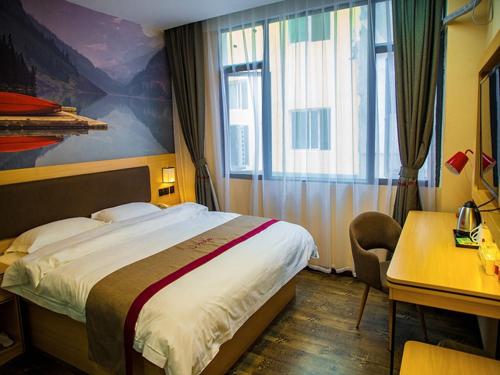 a hotel room with a large bed and a desk at Thank Inn Chain Hotel Guizhou Zunyi Renhuai People's Hospital Store in Zunyi