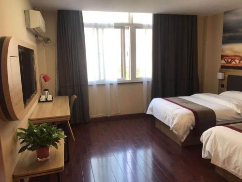 a hotel room with two beds and a window at Thank Inn Chain Hotel Jiangsu Nanjing Jiangning Taowu in Nanjing