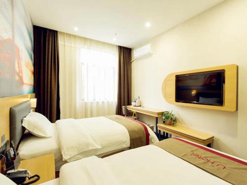 a hotel room with two beds and a flat screen tv at Thank Inn Chain Hotel Xi'an Weiyang District High Speed Rail North Passenger Station in Xi'an