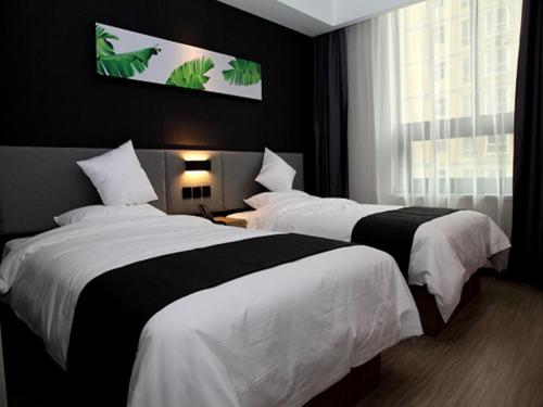 um quarto de hotel com duas camas e uma janela em Up And In Shan'xi Xi'an Weiyang District Yangguang Beijun em Xi'an