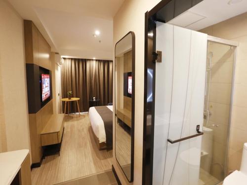a bedroom with a bed and a bathroom with a shower at Up and In Kashgar Xiyu Avenue Food Street in Kashgar