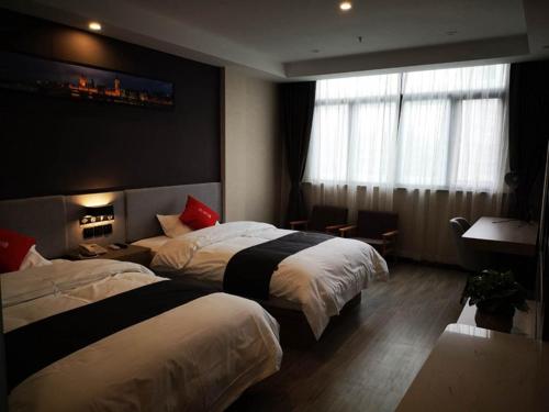 a hotel room with two beds and a window at Thank Inn Plus Hotel Jiangsu Taizhou Taixing City Jiangping Middle Road Store in Taizhou