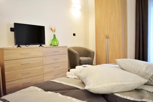a bedroom with a dresser with a television on it at La Gravina in Gravina in Puglia
