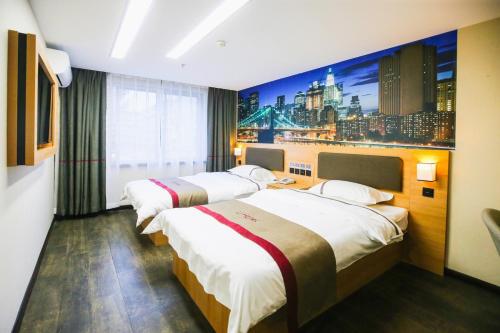 two beds in a hotel room with a city backdrop at Thank Inn Chain Hotel Panjin Shuangtaizi District Railway Station in Panjin