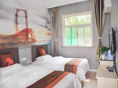 a hotel room with three beds and a window at JUN Hotels Jinzhong Yuci District Railway Station in Jinzhong