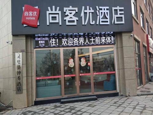 a store with a sign on the front of a building at Thank Inn Chain Hotel Anhui Suzhou Lingbi County People's Hospital Zhongxiu Jincheng in Suzhou