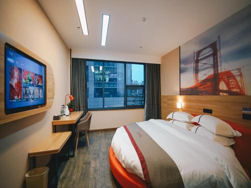 a hotel room with a bed and a desk and a television at Thank Inn Chain Hotel Yancheng Tinghu District Changting Commercial building in Yancheng