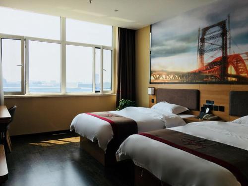 a hotel room with two beds and a painting on the wall at Thank Inn Chain Hotel Hebei Baoding Jingxiu District Lugang International in Baoding
