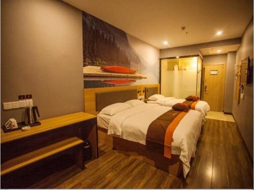 a hotel room with two beds and a bench in it at JUN Hotels Hebei Hengshui Taocheng District Heping West Road in Hengshui