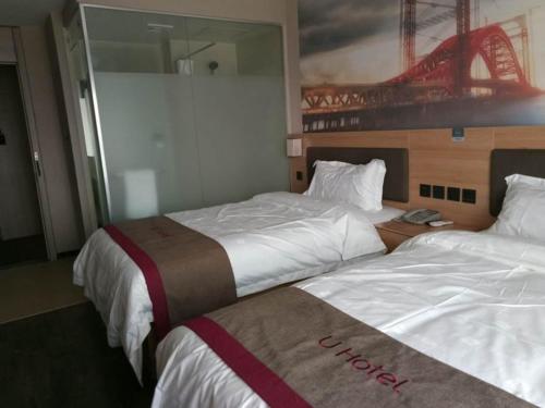 een hotelkamer met 2 bedden en een spiegel bij Thank Inn Chain Hotel Jiangsu Suzhou Wuzhong Hongzhuang Subway Station in Suzhou