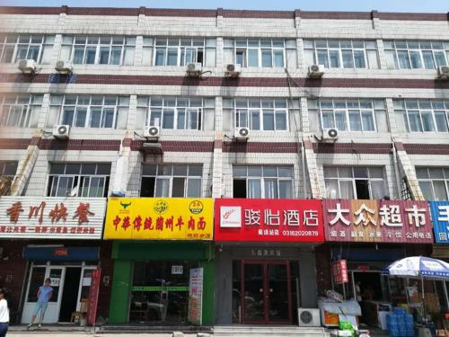 a large building with signs on the front of it at JUN Hotels Hebei Langfang Guangyang Langfang Station in Langfang