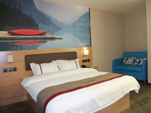 a large bed in a hotel room with a painting on the wall at Thank Inn Chain Hotel Shandong Jining Zoucheng Center Store Town Store in Jining