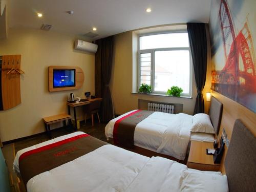 um quarto de hotel com duas camas e uma janela em Thank Inn Chain Hotel Heilongjiang Jiamusi Qianjin District Railway Station em Jiamusi