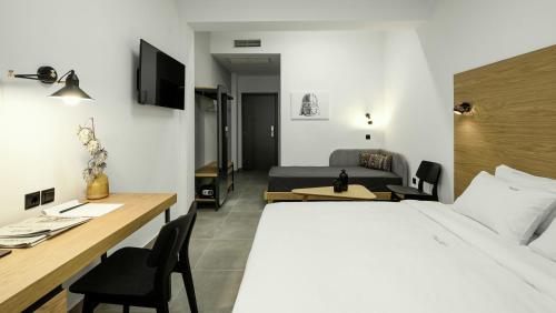 Habitación de hotel con cama, escritorio y cama en Pillow urban stay, en Tesalónica