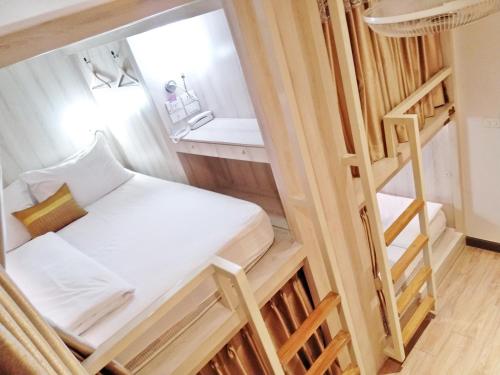 a small room with a bed and a ladder at Mariya Lady Hostel Suvarnabhumi Airport in Lat Krabang