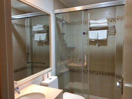 a bathroom with a shower and a sink and a toilet at JUN Hotels Anhui Suzhou Lingbi County Riyue Star City Laidi Shopping Street Store in Suzhou