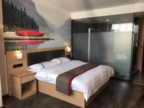 ein Schlafzimmer mit einem großen Bett mit einem Gemälde an der Wand in der Unterkunft Thank Inn Chain Hotel Guangdong Dongguan Daling Mountain Guanchang Road in Dongguan