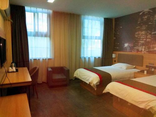 Habitación de hotel con 2 camas y escritorio en Thank Inn Chain Hotel Xinxiang Yuanyang Jianshe Road Hualong Shangjun, en Xinxiang