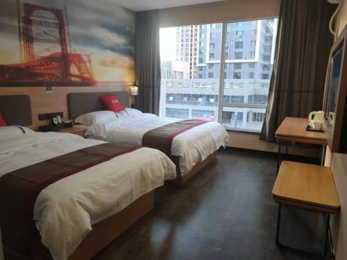 a hotel room with two beds and a large window at Thank Inn Chain Hotel Lanzhou Chengguan District Jiaojiawan Subway Station in Lanzhou